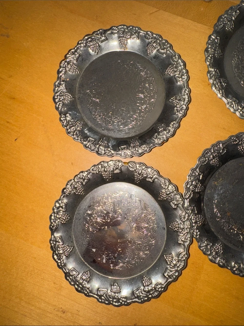 six vintage silver-plated drink coasters with ornate, embossed floral